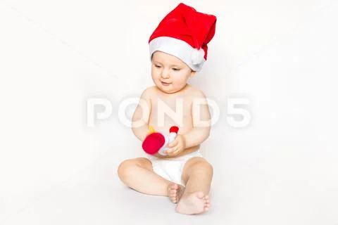 Christmas and family concept - cute funny baby in red santa hat sitting on white Stock Photos
