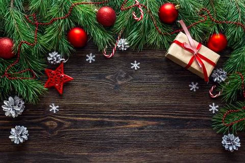 Christmas background with border from pine branches and decorations on dark w Stock Photos