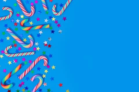 Christmas background with different candy cane and star confetti on blue. 스톡 사진