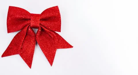 Christmas background featuring a red glitter bow on a clean neutral backdrop Stock Photos