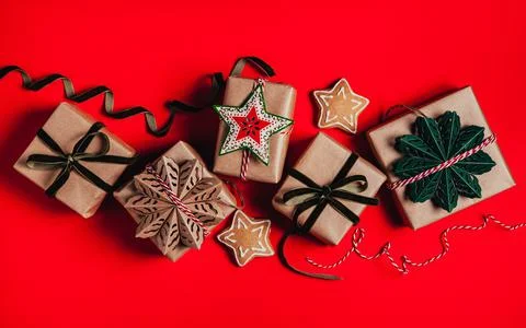 Christmas background with gift boxes, clews of rope and decorations on red. P Фото