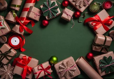 Christmas background with gift boxes, clews of rope and decorations on green. Фото