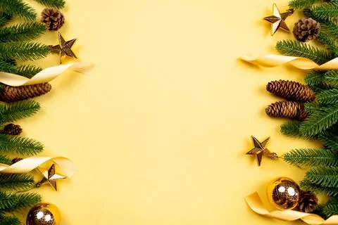 Christmas background, pine tree with xmas decoration on yellow background Stock Photos