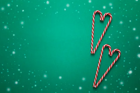 Christmas background with red candy canes in the shape of heart. Copy space. Stock Photos