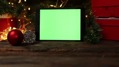 Christmas background red gift box tablet gadget green screen wooden table lights Stock Footage 164485700