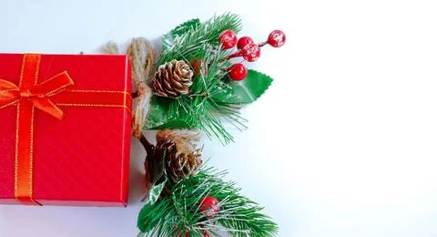 .Christmas background with red gift box wrapped in ribbon, pine branches Stock Photos