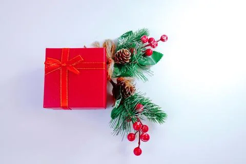 .Christmas background with red gift box wrapped in ribbon, pine branches Stock Photos