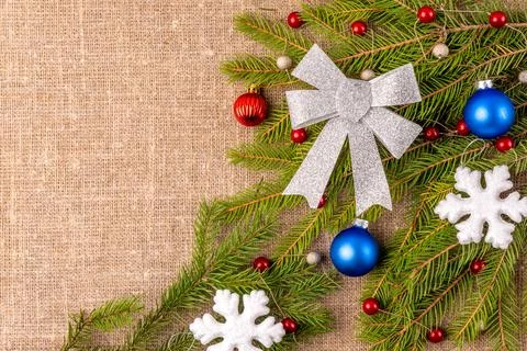 Christmas background with the texture of burlap, tree branches and toys Stock Photos