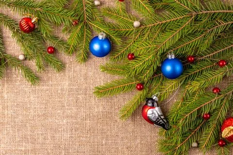 Christmas background with the texture of burlap, tree branches and toys Stock Photos