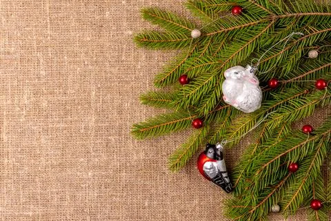 Christmas background with the texture of burlap, tree branches and toys Photos