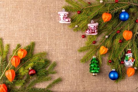 Christmas background with the texture of burlap, tree branches and toys Photos