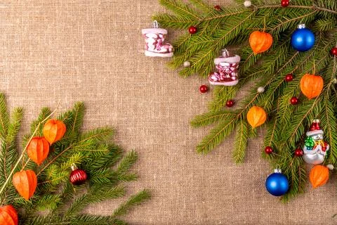 Christmas background with the texture of burlap, tree branches and toys Stock Photos