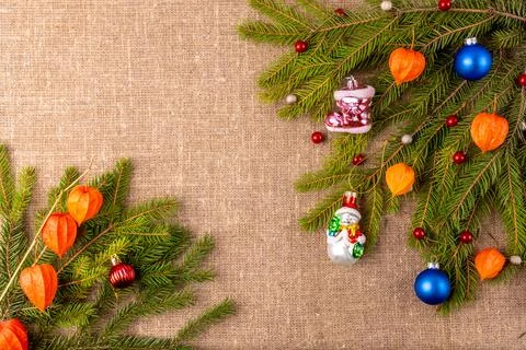 Christmas background with the texture of burlap, tree branches and toys Stock Photos