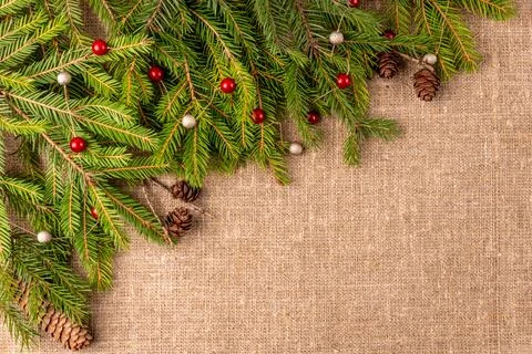 Christmas background with the texture of burlap, tree branches and toys Stock Photos