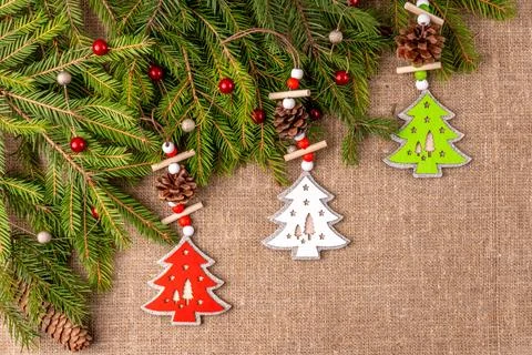 Christmas background with the texture of burlap, tree branches and toys Photos