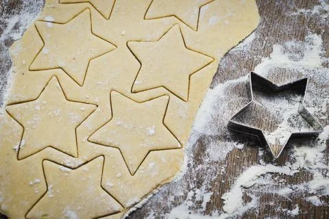 Christmas baking. Making gingerbread biscuits. Cookie dough and cookie cutter. Stock Photos