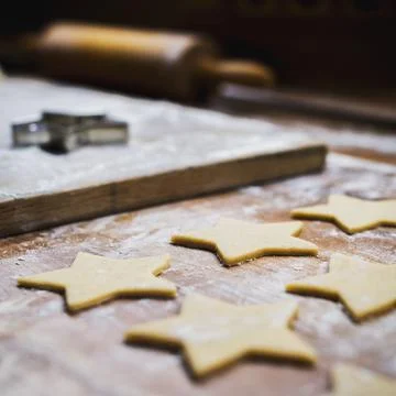 Christmas baking. Making gingerbread biscuits. Cookie dough and cookie cutters. Stock Photos