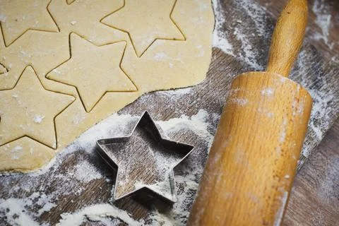 Christmas baking. Making gingerbread biscuits. Cookie dough and cookie cutters. Stock Photos