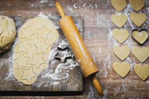 Christmas baking. Making gingerbread biscuits. Cookie dough and cookie cutter. Stock Photos