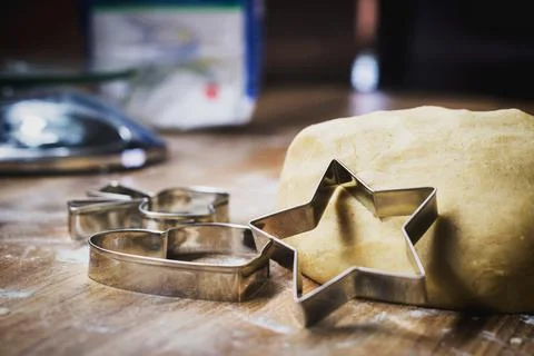 Christmas baking. Making gingerbread biscuits. Cookie dough and cookie cutter. Stock Photos