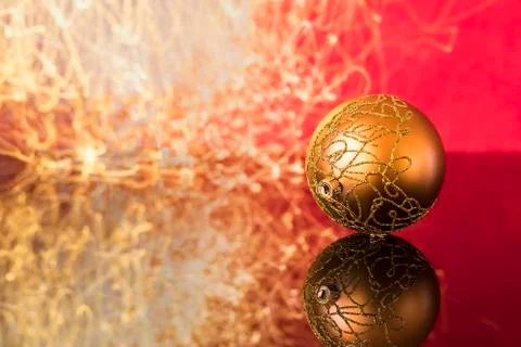 Christmas ball with reflection on red background and lights trails Foto stock