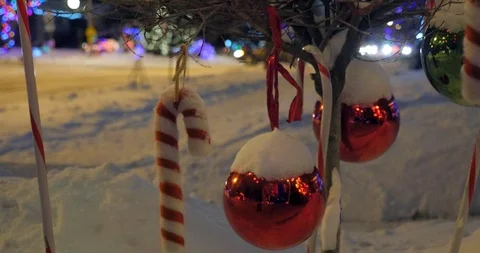 Christmas balls and Candy Canes dance on a tree branch on a snowy winter night 库存影片 100659727
