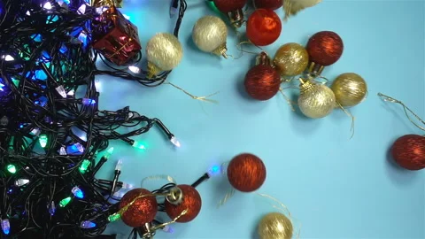 Christmas balls falling in slow motion on glowing garland Stock Footage 142560301