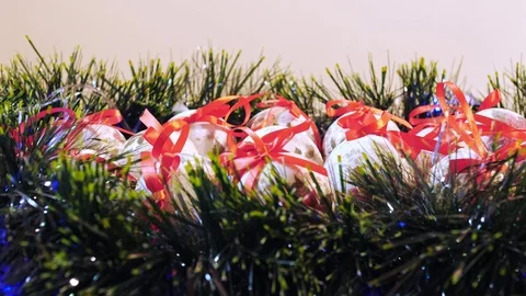 Christmas balls lying on the table with christmas wreath and green tinsel. Stock Footage 83085994