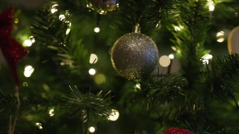A Christmas bauble with white snowflake patterns hangs on a green fir branch Stock Footage 324920800