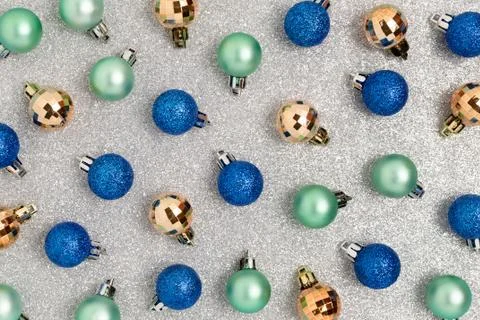 Christmas baubles pattern on a silver glowing texture. Stock Photos