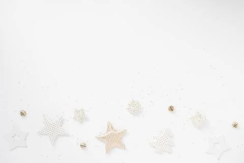 Christmas border. Golden stars, bells and bows on white background. Flat lay Stock Photos