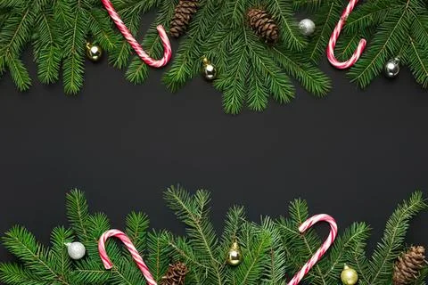 Christmas border with pine branches candy canes and ornaments Stock Photos