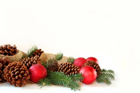 Christmas bulb, pine cone, and evergreen border isolated on white background Stock Photos