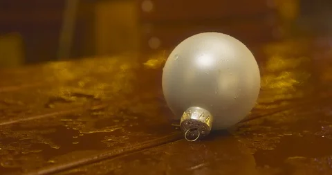 A Christmas bulb, placed on a table top on a rainy evening Vídeos de archivo 110291939