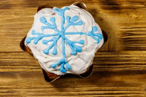 Christmas cake decorated with white glaze and snowflake on wooden table Stock Photos