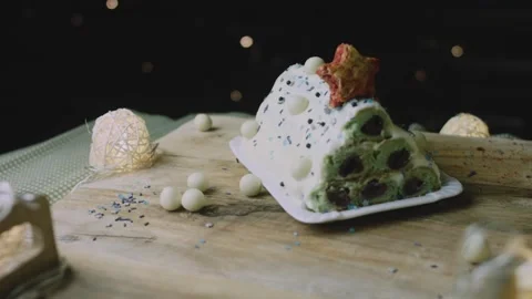 Christmas cake presented beneath glowing string lights Stock Footage 342129524