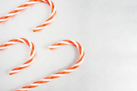 Christmas candy canes laying down on a grey background. Stock Photos