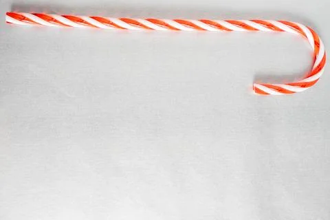 Christmas candy canes laying down on a grey background. Stock Photos