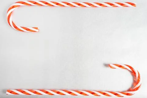 Christmas candy canes laying down on a grey background. Stock Photos