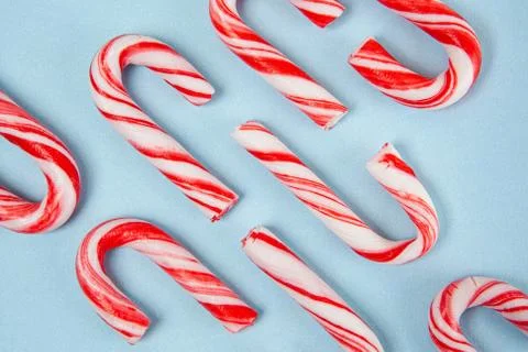 Christmas candy canes pattern on blue background - top view Stock Photos