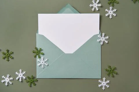 Christmas card flat lay. Empty card in green envelope. Mockup. Stock Photos