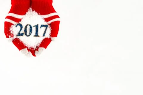 Christmas card, gloves on hands holding snow and 2017 new year isolated on .. Photos