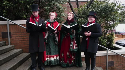 Christmas Caroling quartet on steps of small mall singing carols, 4k Stock Footage 221205321