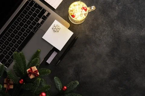 Christmas cheer at work. Computer, notebook, notes, garland in a cup and a .. Stock Photos