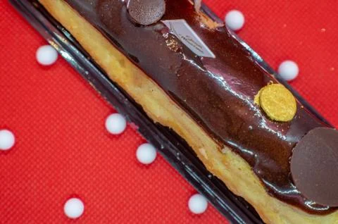 Christmas chocolate Eclair. French Eclair, cake on a Red background.dessert 스톡 사진