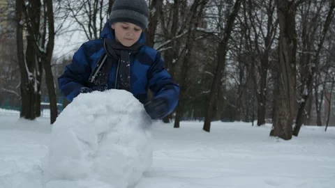 Christmas classes. a boy in a blue jacket sculpts from snow Stock Footage 147270557