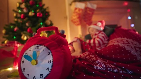 Christmas clock and little boy waiting for Santa on Christmas night Stock Footage 73029463