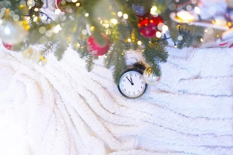 Christmas clock on a white background under an elegant Christmas tree with Stock Photos
