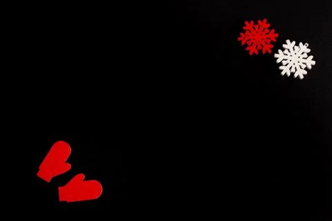 Christmas composition on a black background, snowflakes and mittens, copy space Stock Photos