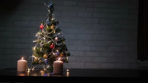 Christmas composition with burning candles and small fir tree in dark room. Stock Footage 166013555